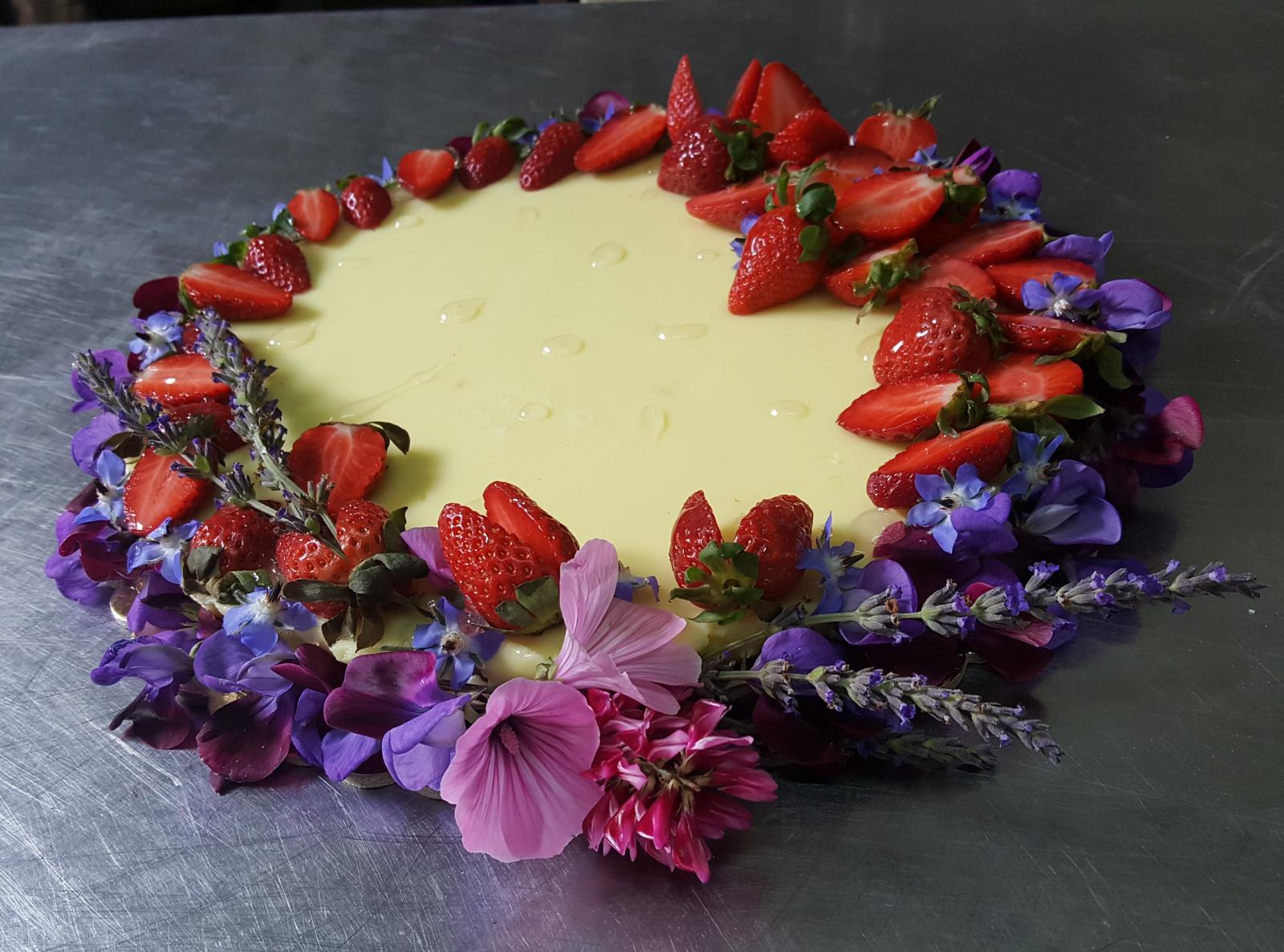 Torta fatta in casa con fiori e fragole, preparata nella cucina di Mariscò
