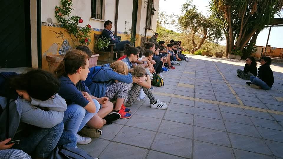 Gruppo seduto in ascolto durante un momento collettivo in azienda