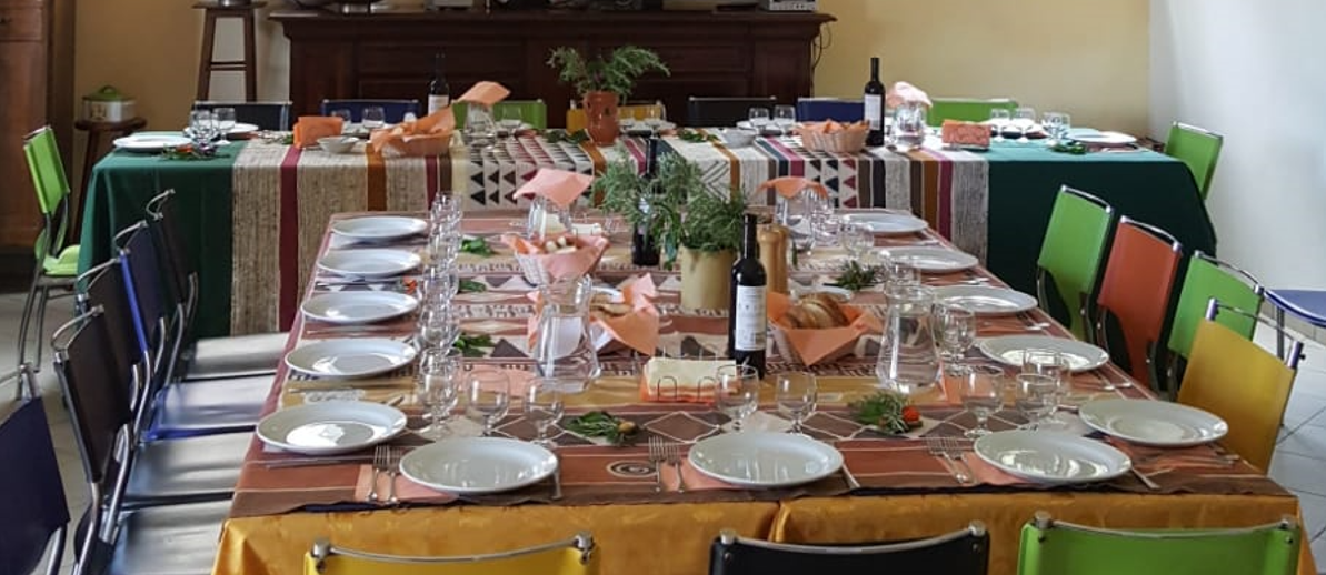 Tavolata apparecchiata in sala ristorante per pranzo di gruppo